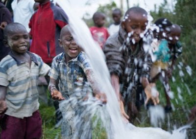 Bret Kenya Kids play in water from new well